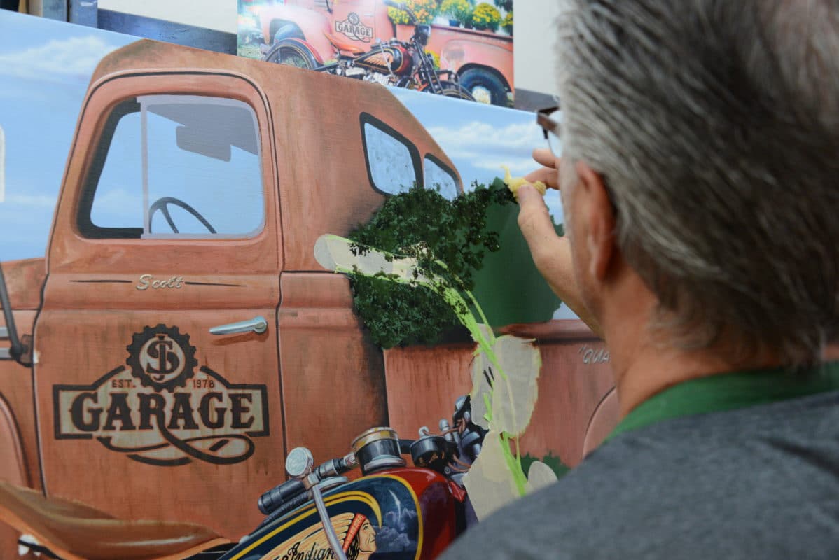 Scott Jacobs painting flowers in a pickup