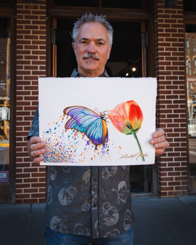 scott jacobs holding a butterfly painting called "color my world"