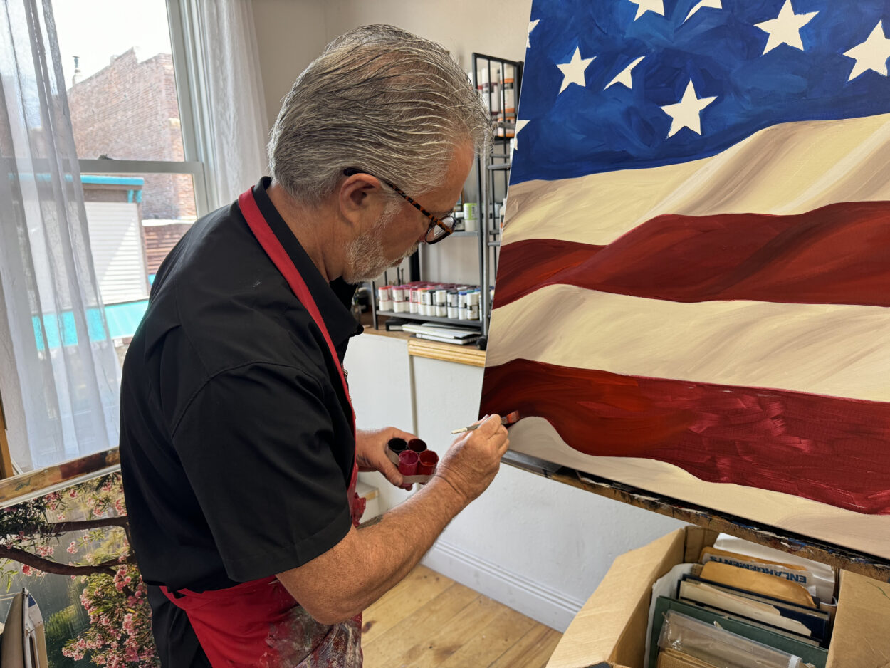 Scott Jacobs working on a patriotic painting of an American flag