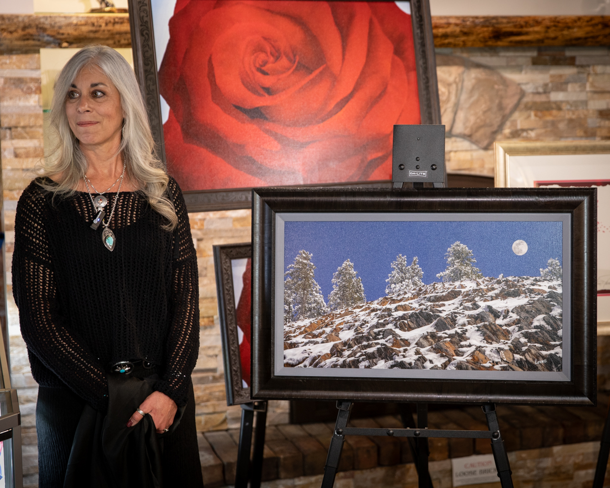 photo of traci Lovell presenting her husband's Buck Lovell's photograph of a nightscape